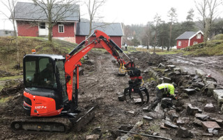 Restaurering av gamle steinmurer er et møysommelig arbeid. Eystein Greibrokk gjør handarbeidet, mens Anders Oppegaard styrer gravemaskinen. Foto: Asbjørn Aanonsen